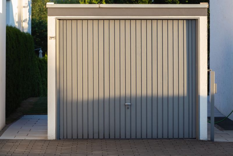 enclosed carport with a grey gate
