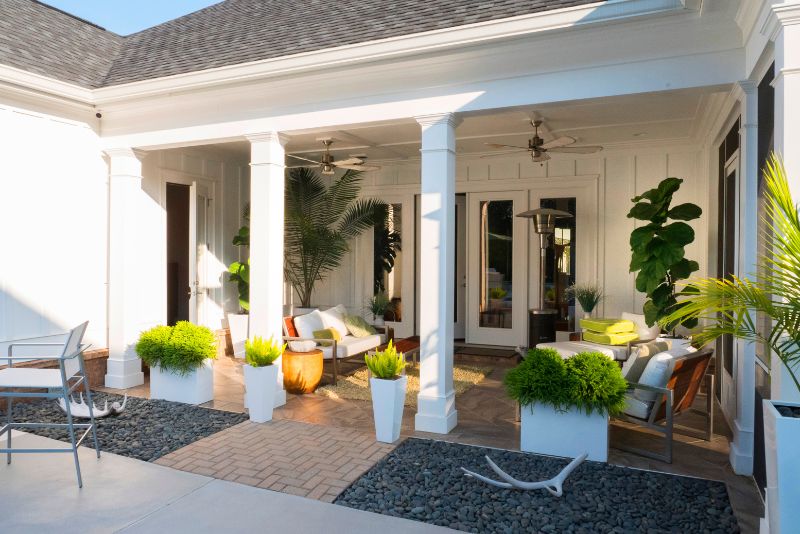 verandah decorated with potted plants and outdoor furniture