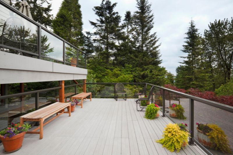 composite deck decorated with two benches and potted plants